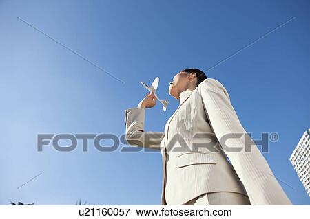 Stock Photo - Businesswoman holding a paper airplane. Fotosearch