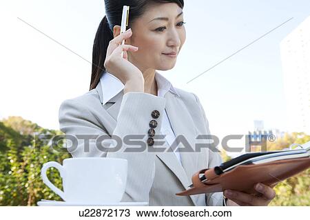 Businesswoman holding diary and pen View Large Photo Image Stock Image - Businesswoman holding diary and pen. Fotosearch