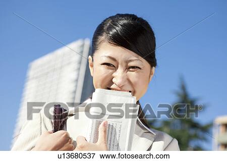 Businesswoman holding newspaper View Large Photo Image Stock Photo - Businesswoman holding newspaper. Fotosearch