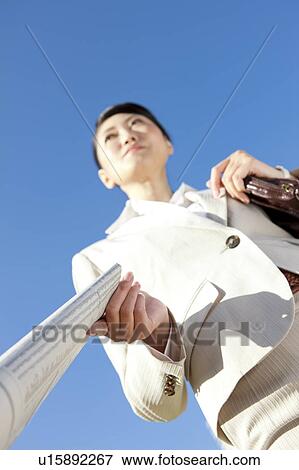 Businesswoman holding newspaper View Large Photo Image Stock Photo - Businesswoman holding newspaper. Fotosearch