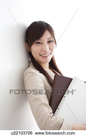 Stock Photograph - Businesswoman holding ring binders. Fotosearch