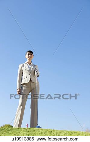Stock Photograph - Businesswoman in suit playing golf. Fotosearch