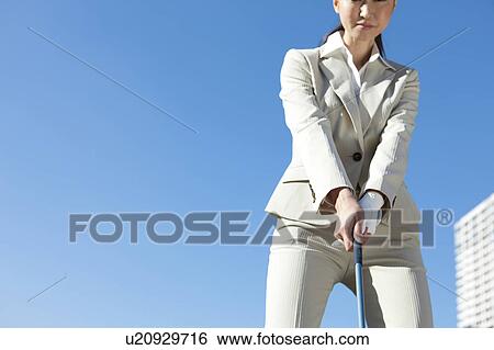 Stock Photograph - Businesswoman in suit playing golf. Fotosearch
