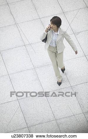 Stock Photo - Businesswoman on cell phone, High Angle View. Fotosearch