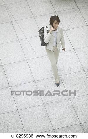 Stock Photograph - Businesswoman on cell phone, High Angle View. Fotosearch
