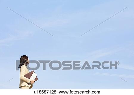 Businesswoman on rooftop holding ring binder View Large Photo Image Stock Photo - Businesswoman on rooftop holding ring binder. Fotosearch