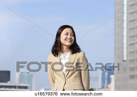 Stock Photograph - Businesswoman on rooftop smiling. Fotosearch