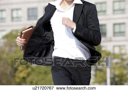 Stock Photo - Businesswoman running, Midsection. Fotosearch