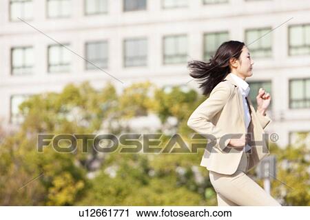 Stock Image - Businesswoman running. Fotosearch