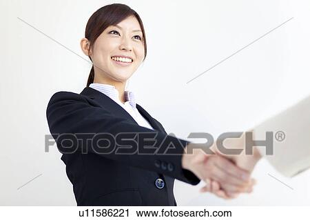 Stock Image - Businesswoman shaking hands. Fotosearch