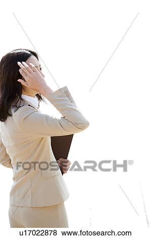Stock Photo - Businesswoman standing holding ring binder. Fotosearch