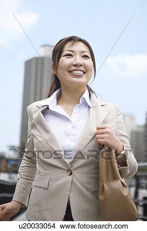 Picture - Businesswoman walking in financial district. Fotosearch