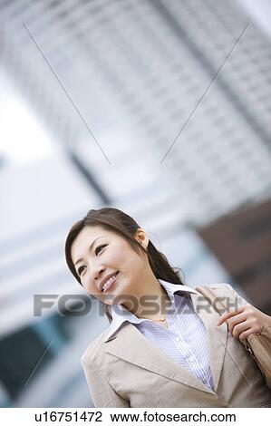 Stock Image - Businesswoman walking in financial district. Fotosearch