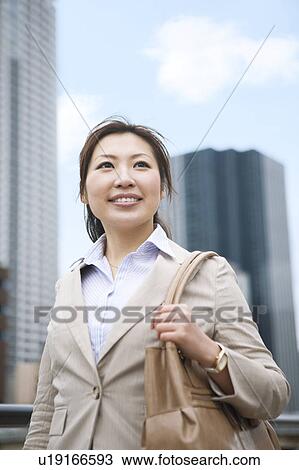 Stock Image - Businesswoman walking in financial district. Fotosearch