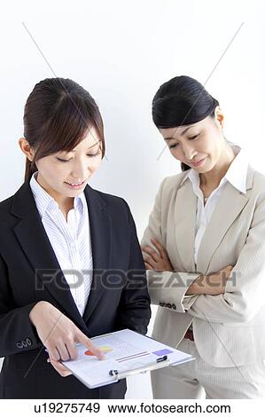 Businesswomen looking at document View Large Photo Image Stock Photo - Businesswomen looking at document. Fotosearch