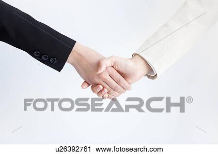 Stock Image - Businesswomen shaking hands. Fotosearch