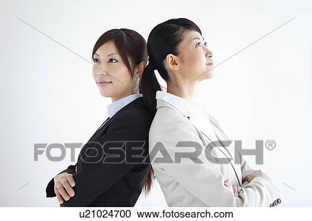Businesswomen standing back to back View Large Photo Image Stock Image - Businesswomen standing back to back. Fotosearch