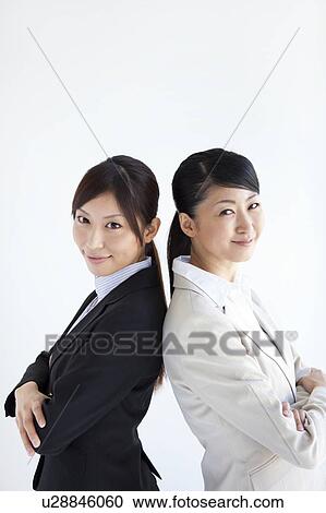 Businesswomen standing back to back View Large Photo Image Stock Image - Businesswomen standing back to back. Fotosearch