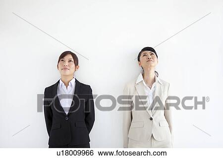 Businesswomen standing side by side looking up View Large Photo Image Stock Photograph - Businesswomen standing side by side looking up. Fotosearch