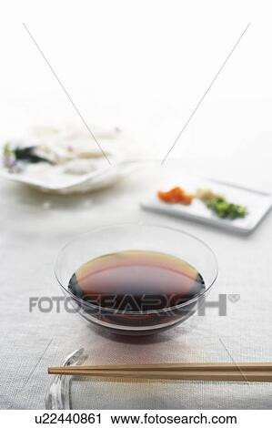 Stock Image - Chopsticks and sauce in glass bowl. Fotosearch