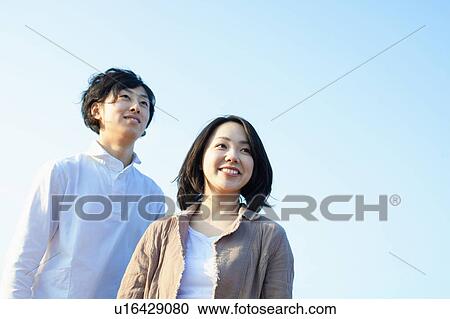 Stock Image - Clear Blue Sky Over Young Couple. Fotosearch