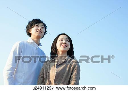 Stock Photo - Clear Blue Sky Over Young Couple. Fotosearch