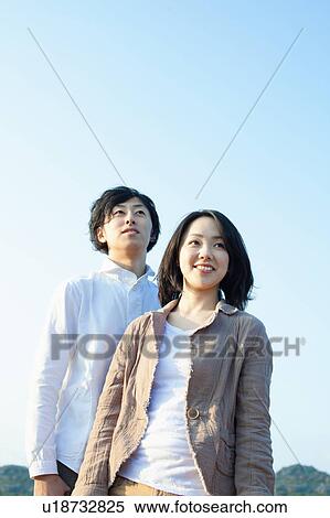 Stock Photography - Clear Blue Sky Over Young Couple. Fotosearch