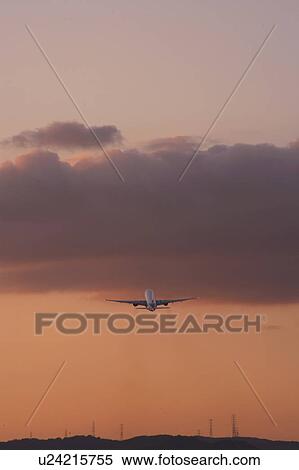 Stock Photography - Commercial Airplane taking off at dusk, Osaka Prefecture, Honshu, Japan. Fotosearch