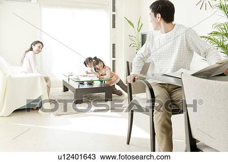 Family of Four in Living Room, Father Using Laptop View Large Photo Image Stock Image - Family of Four in Living Room, Father Using Laptop. Fotosearch