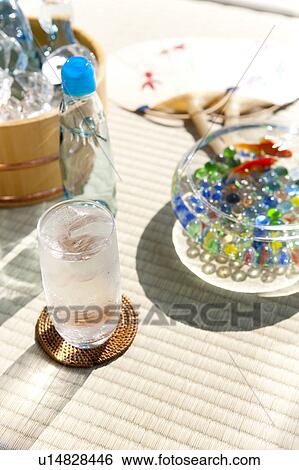Stock Photograph - Glass of soda, bottle of sodas and goldfishes in fishbowl. Fotosearch