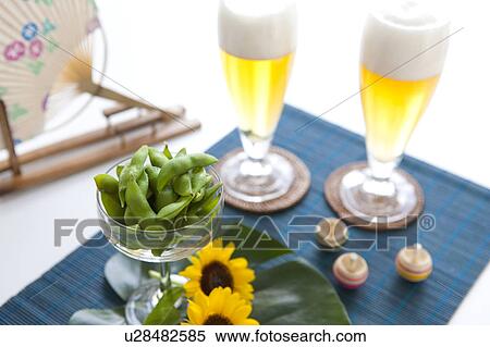 Glasses of beer, edamame, sunflowers, tops and fan on place mat View Large Photo Image Stock Photography - Glasses of beer, edamame, sunflowers, tops and fan on place mat. Fotosearch