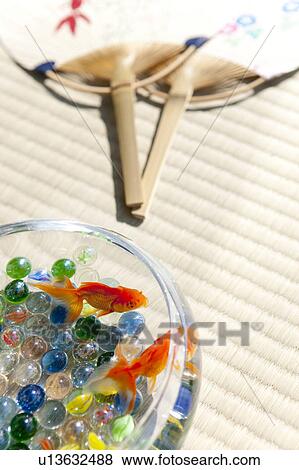 Stock Photo - Goldfishes swimming in fishbowl and fan. Fotosearch