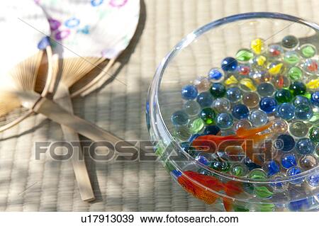 Stock Photo - Goldfishes swimming in fishbowl and fan. Fotosearch