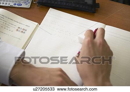 Stock Image - High school boy writing on note pad, Japan. Fotosearch