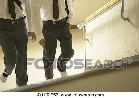 Stock Image - High school boys climbing up the staircase, Japan. Fotosearch