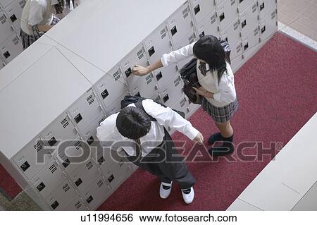 Stock Photograph - High school student at locker changing shoes, Japan. Fotosearch