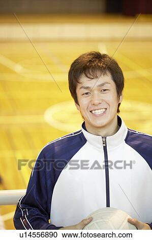 Stock Image - High school student holding volleyball, Japan. Fotosearch