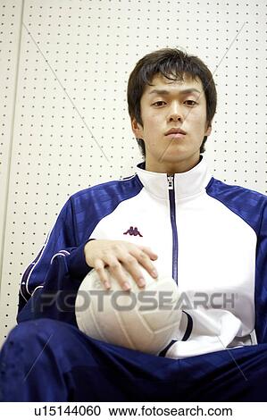 Stock Image - High school student holding volleyball, Japan. Fotosearch
