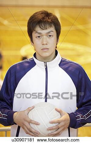 Stock Image - High school student holding volleyball, Japan. Fotosearch
