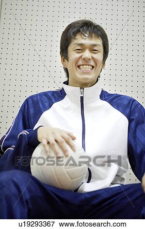 Stock Photo - High school student holding volleyball, Japan. Fotosearch