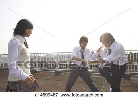 Stock Photo - High school students fighting on rooftop, Japan. Fotosearch