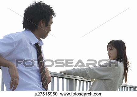 Stock Image - High school students talking on rooftop, Japan. Fotosearch