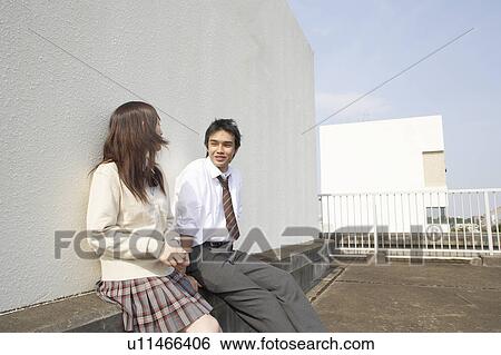 Stock Photograph - High school students talking on rooftop, Japan. Fotosearch