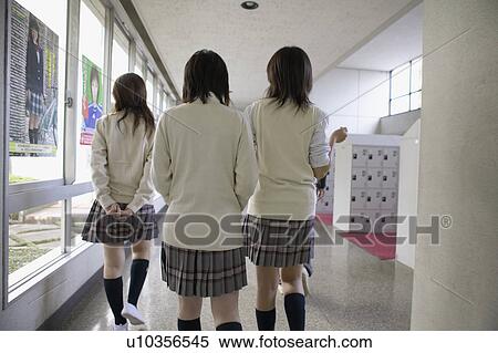 Stock Photography - High school students walking corridor, rear view, Japan. Fotosearch
