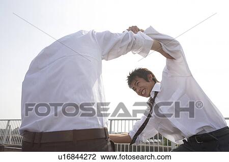 Stock Image - High school students wrestling on rooftop, Japan. Fotosearch