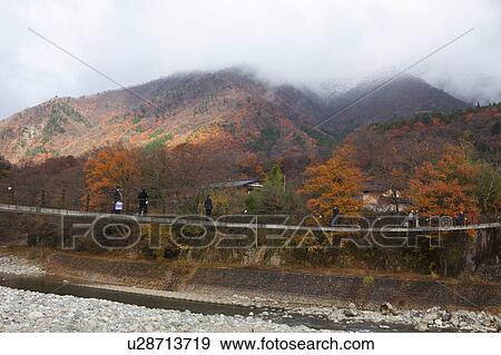 Stock Photo - Hikers Crossing Footbridge. Fotosearch