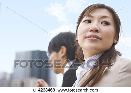 Stock Photo - Low Angle View of Businesswoman and Man Outdoors. Fotosearch