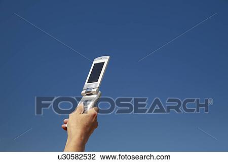 Man's hand holding a cell phone, Osaka Prefecture, Honshu, Japan View Large Photo Image Stock Image - Man's hand holding a cell phone, Osaka Prefecture, Honshu, Japan. Fotosearch