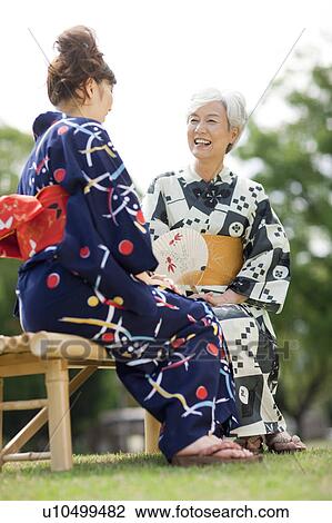 Stock Image - Mother and daughter wearing Yukata and talking. Fotosearch