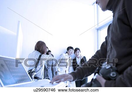 Stock Photograph - Photographer and his staffs taking photos. Fotosearch